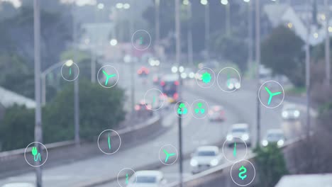 multiple green energy icons floating against aerial view of city traffic