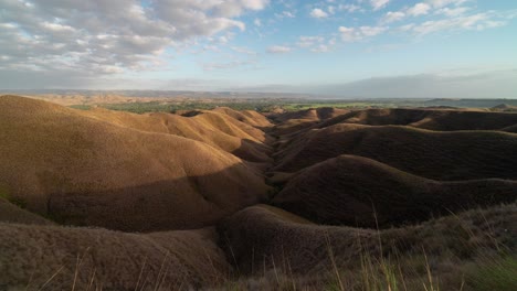 rolling dry hills landscape under a cloudy sky