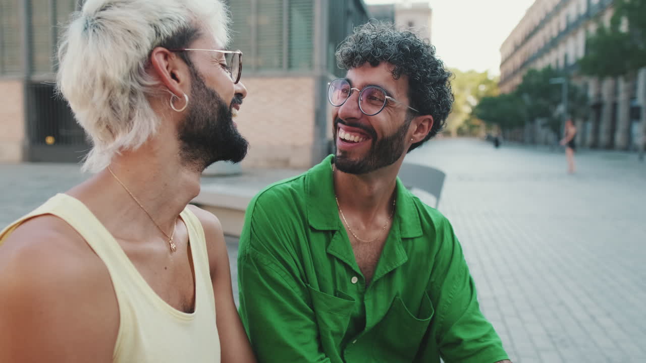 Coppia gay felice che ride e parla per strada in città