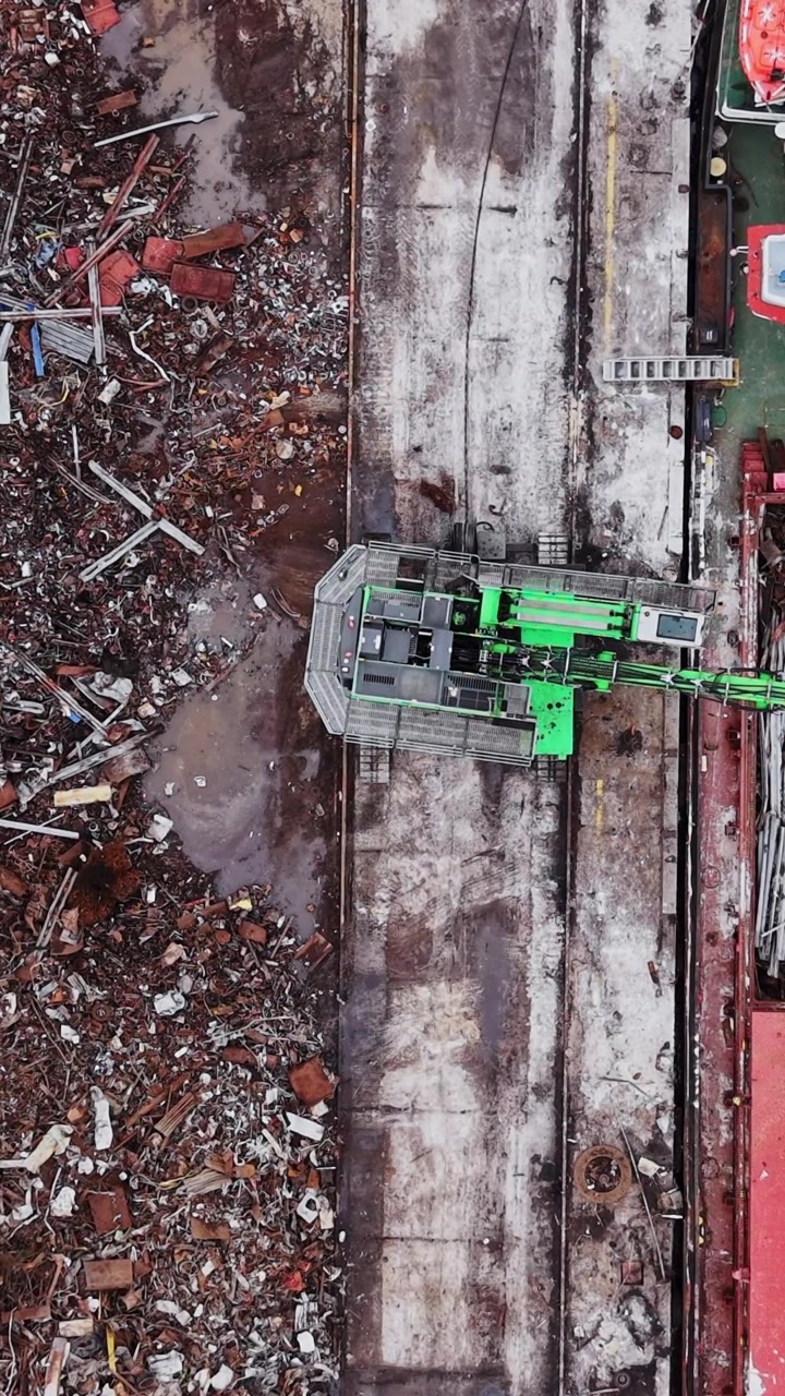 Lavoro in corso in un cantiere navale con carico che viene caricato su un'imbarcazione.