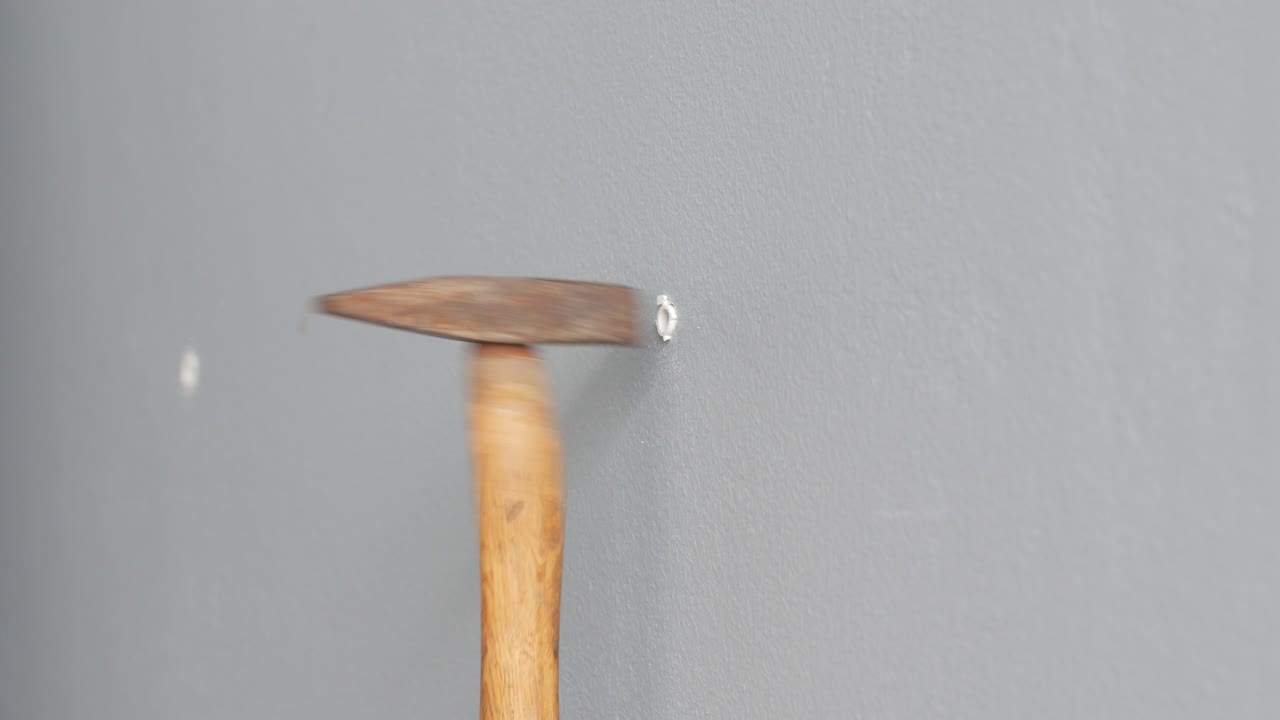 구이 린 회색 벽에 클을 입하고 망치로 때리십시오.