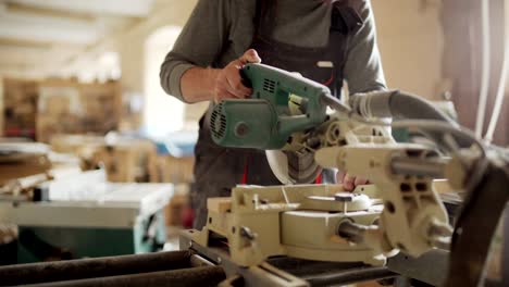 unrecognizable carpenter making cuts in wooden planks using circular saw