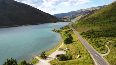 aerial forward view on a fascinating water stream flanked by a promontory and road