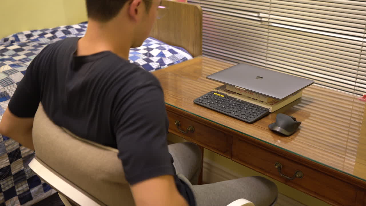 남자는 테이블에 노트북을 놓고 집에서 일을 시작하기 위해 그것을 엽니다