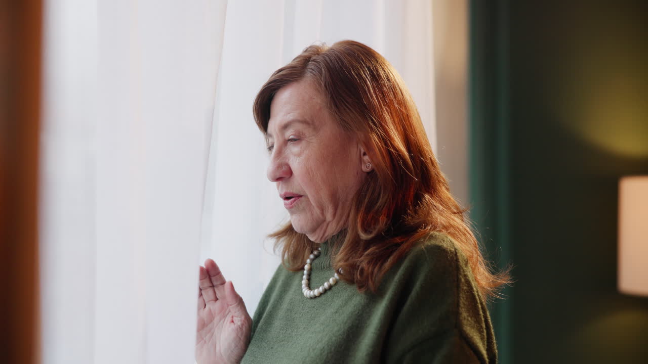 A middle-aged woman looking out the window