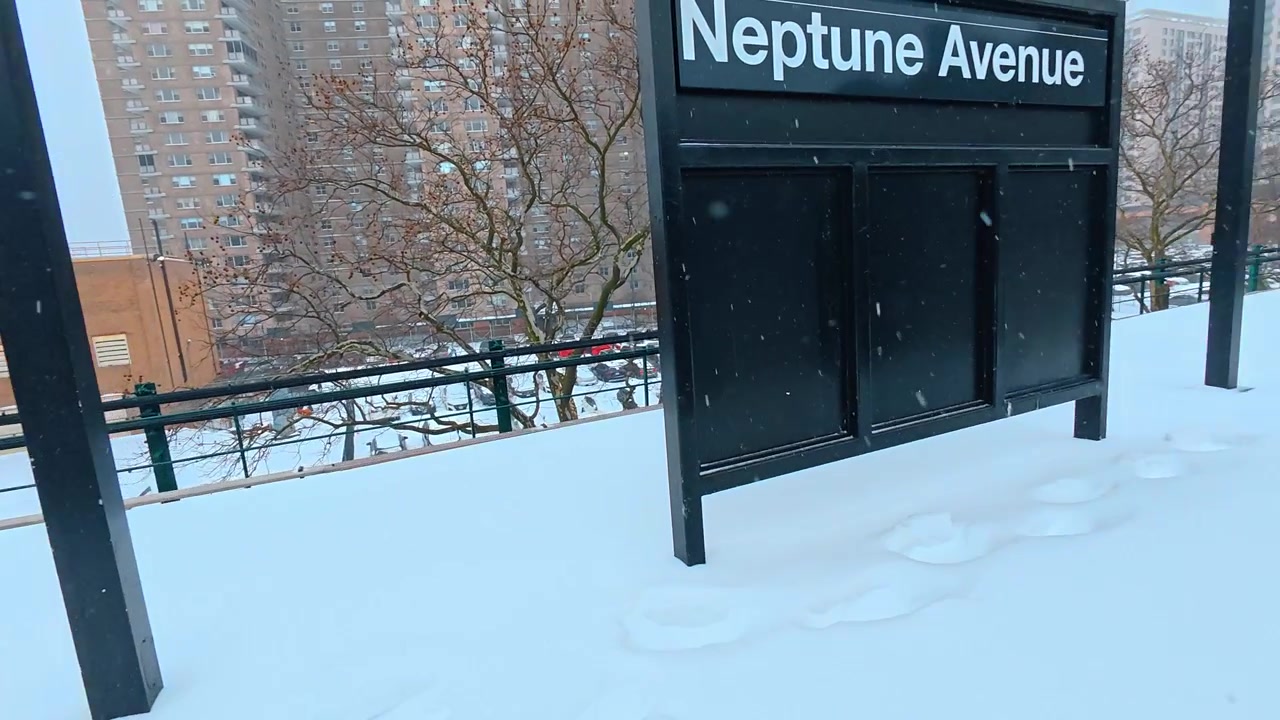 New York, USA, 25 dicembre 2025: Porte aperte della metropolitana su una piattaforma innevata, NYC. La vista dall'interno del vagone mostra binari metallici, neve alta, edifici vicini e una pensilina della piattaforma