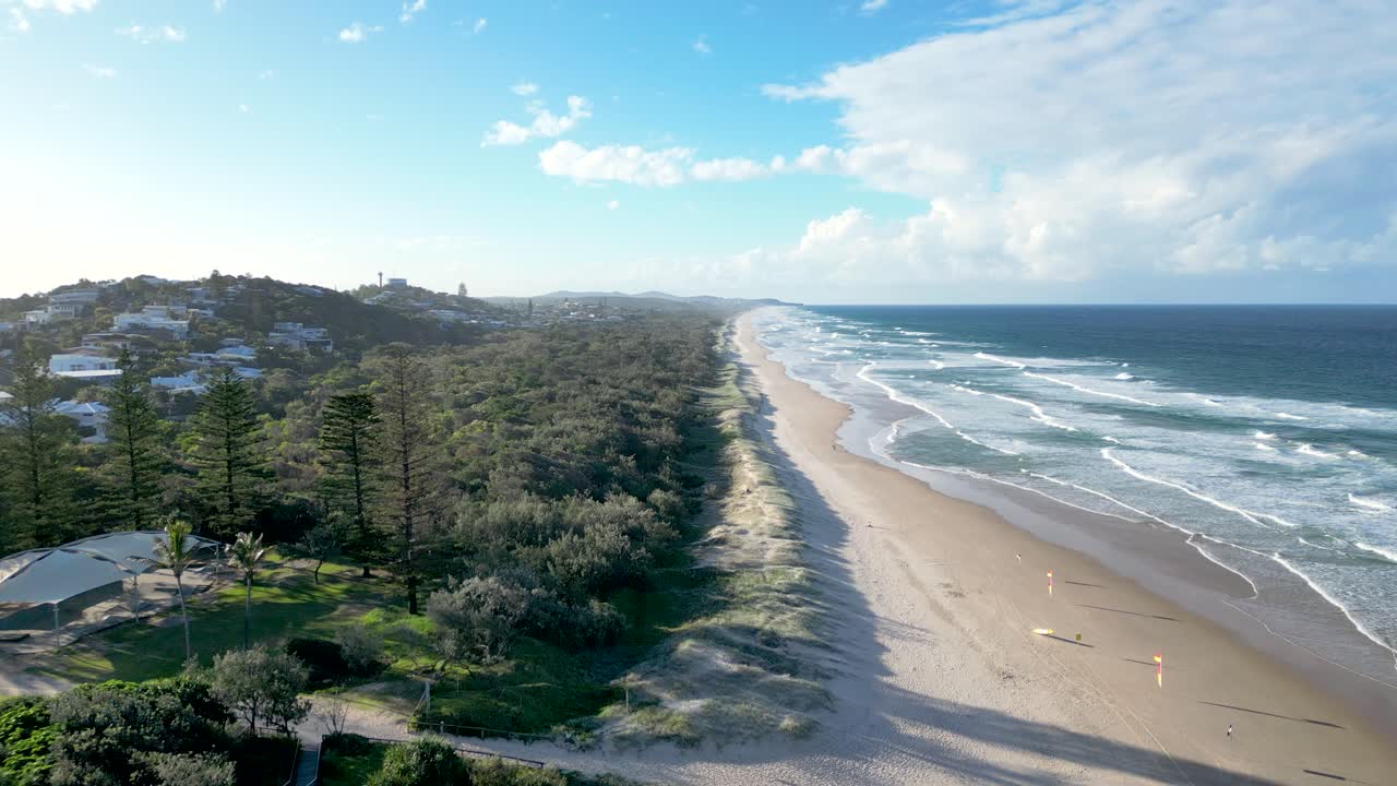 Aerial View of a Beautiful Beach with Waves and Coastal Houses