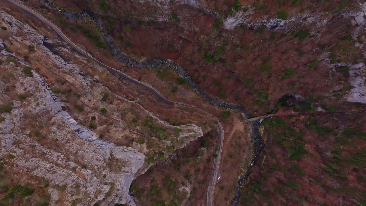 Stejle kløftvægge flankerer vejen i droneperspektiv