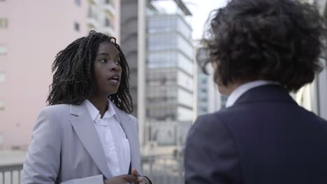 cheerful businesswomen talking on street