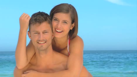 Couple-playing-piggyback-on-a-beach