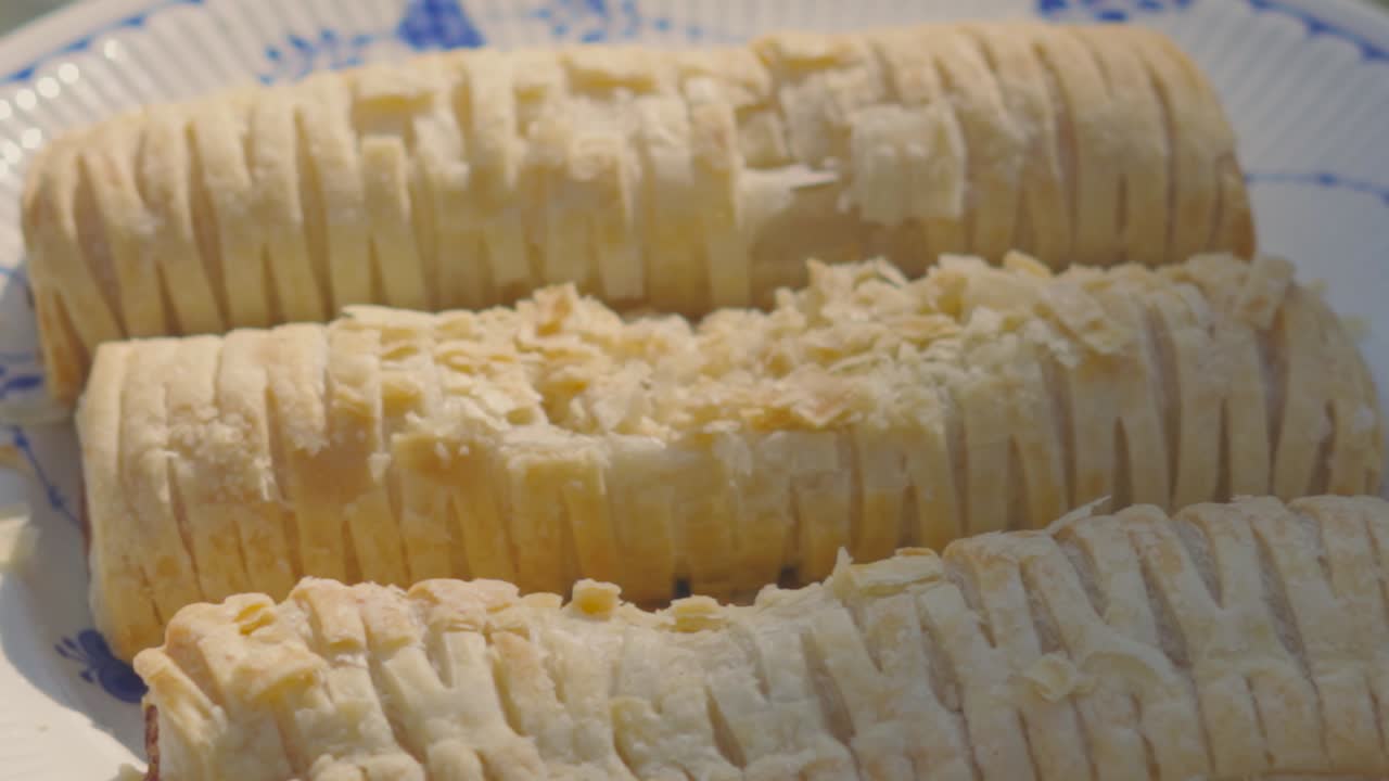 Trio of Sausage Rolls with Flakey Pastry Fall on Plate in Slow Motion Outside in Natural Light. Delicious Fresh Bakery Product. British Traditional Pork Meat Wrapped in Puff Pastry.