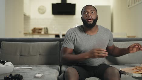 Concentrated-man-looking-at-tv-screen.-Happy-football-fan-biting-pizza.