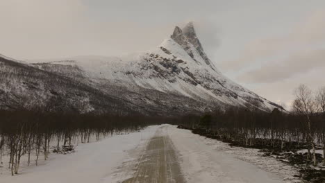 Majestic-Otertinden-mountain-in-moody-arctic-weather,-snow-landscape