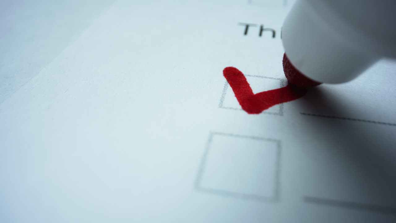 Marker checking boxes in to do list. Person writing check marks in checklist