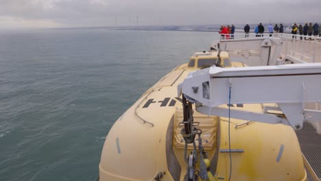 people-overlooking-side-rails-of-ferry-departing-mainland-for-next-destination