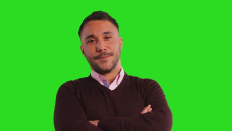 close up studio portrait of male teacher or businessman standing against green screen folding arms