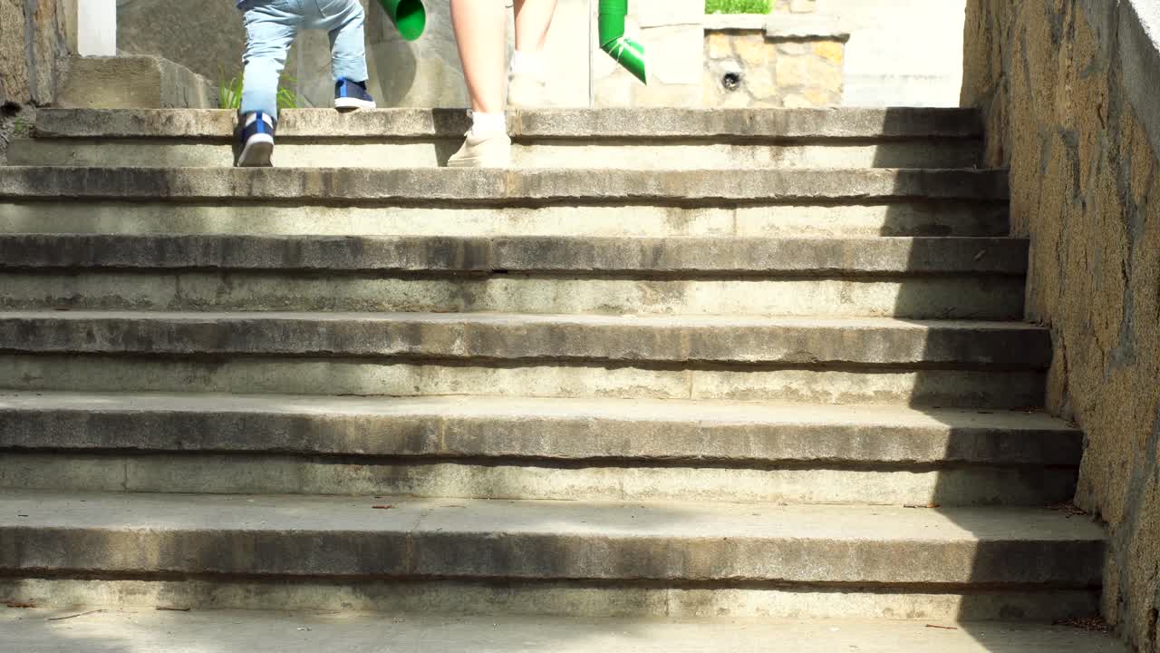 어머니 와 아이 가 돌 의 계단 을 올라가고 있다