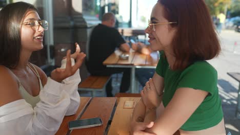 two women talking in an outdoor cafe