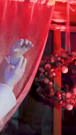 santa claus near beautiful christmas tree. real santa with white beard admires shiny christmas balls hanging on a festive tree. vertical video