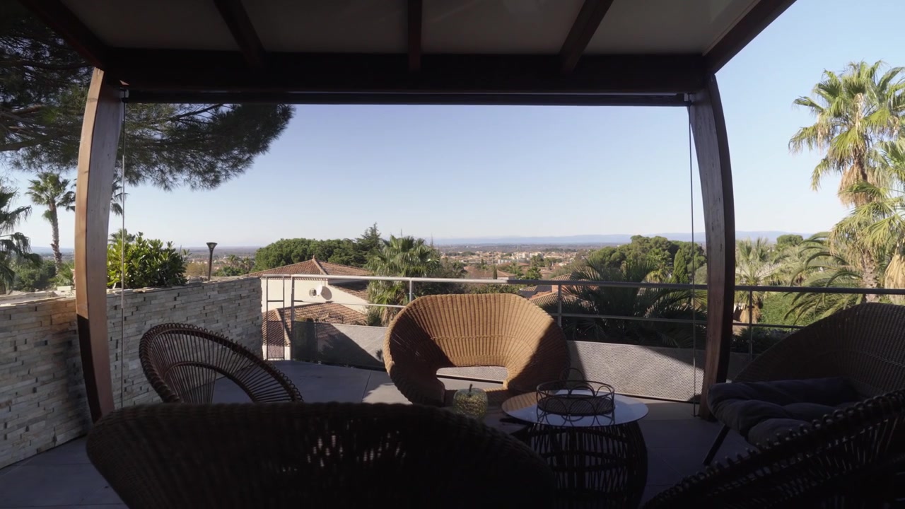 Ampia vista dalla terrazza con mobili da esterno che si affaccia su tetti lontani e vegetazione