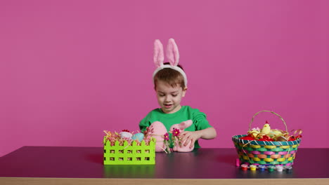 Joyful-young-kid-playing-around-with-festive-painted-decorations