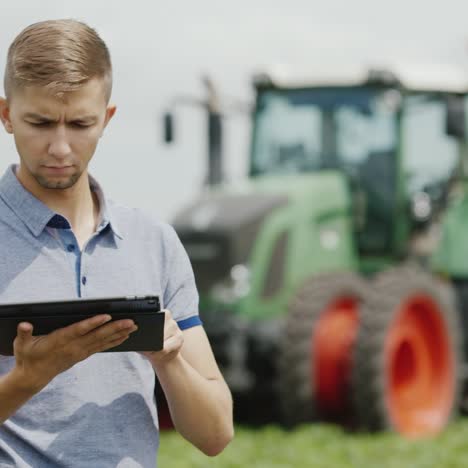 a young tractor driver uses a tablet