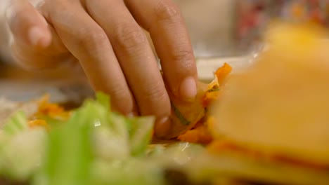 un primerísimo plano de los dedos recogiendo curry con panqueque dosa recién cocinado