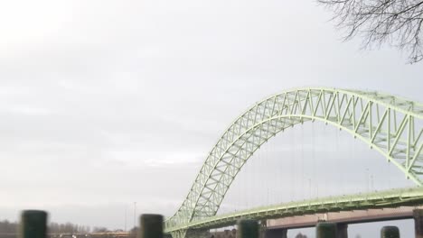 runcorn silver jubilee bridge parallax detrás de las barandillas del parque de hierro - espacio verde del árbol del paseo marítimo