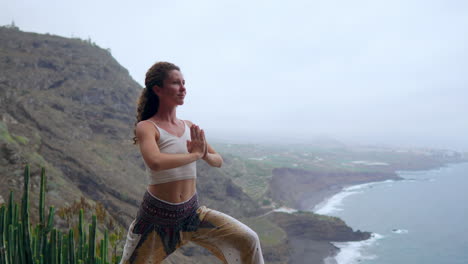 en una costa rocosa durante la puesta de sol, una joven practica yoga, destacando un estilo de vida saludable, la armonía y la unidad de los humanos y la naturaleza con el fondo del océano azul