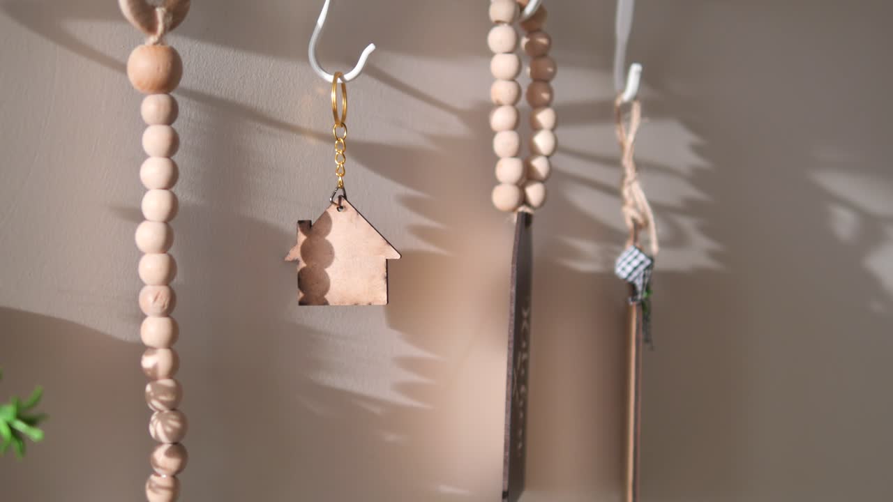Portachiavi a forma di casa in legno appeso a un gancio con luce solare