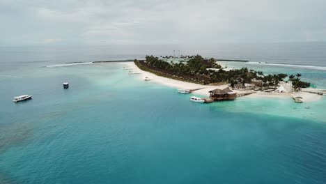 drone volando al puerto con yates de una isla en las maldivas 4k