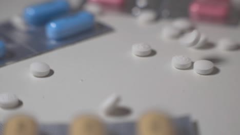 white pills drop and scattered on a white table