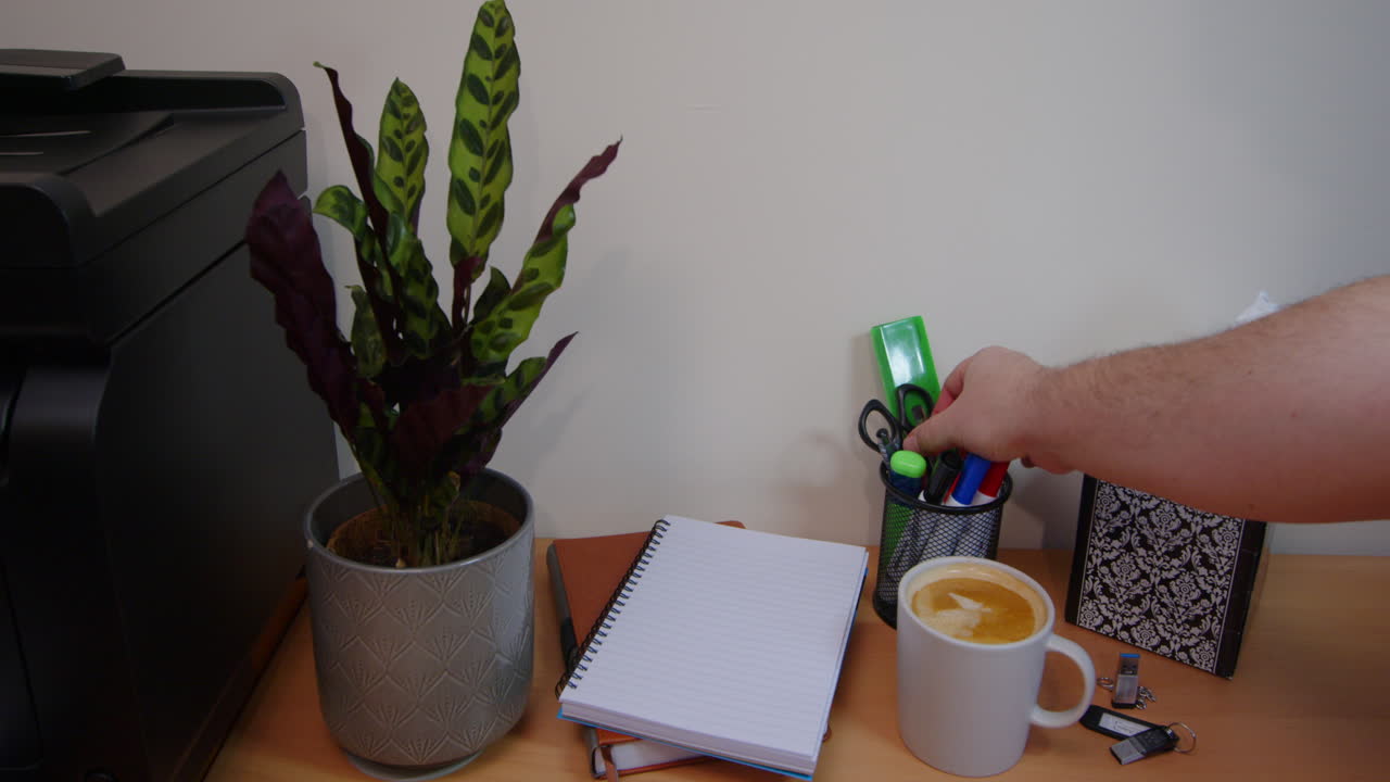 oficina en casa dejando un café y recogiendo un bolígrafo, ws