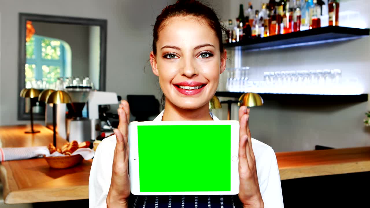 retrato de una hermosa camarera con una tableta digital en el mostrador