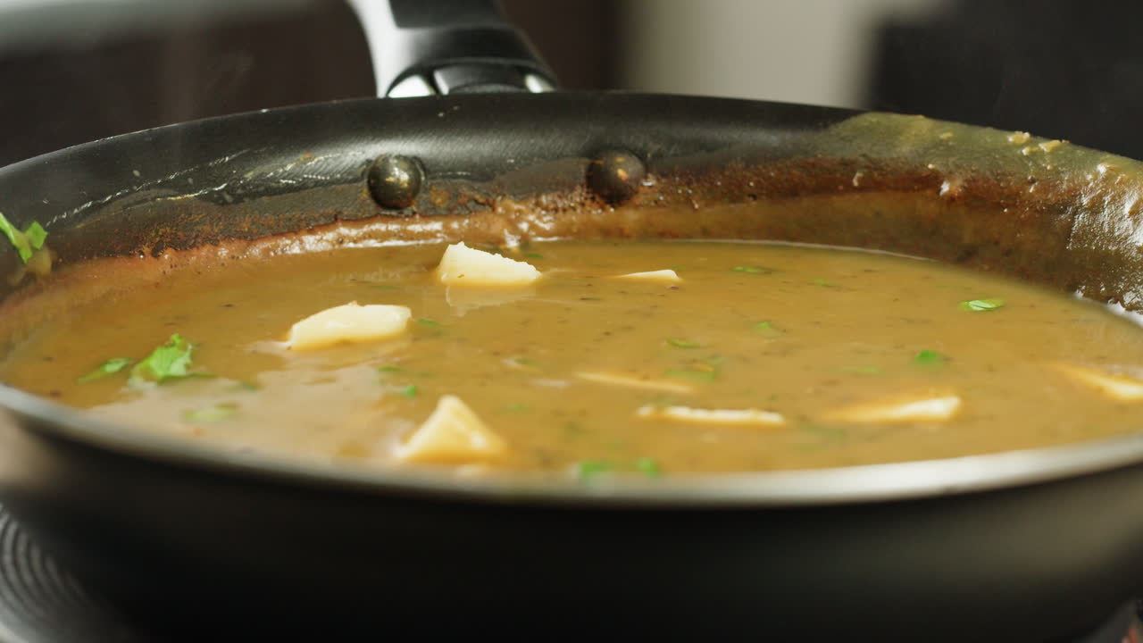 Cooking traditional Indian meal Palak Panir with spinach and cheese close up. Palak paneer is an Indian dish, consisting of paneer in a thick paste made from pureed spinach, Palak paneer is prepared by first boiling and pureeing spinach.