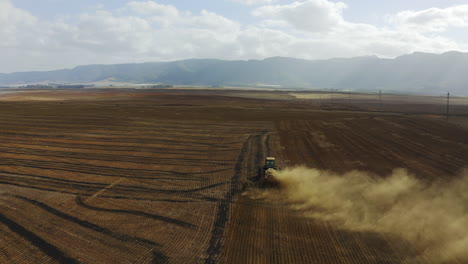 4K-Drohnenaufnahmen-Eines-Traktors,-Der-Ein-Feld-Pflügt