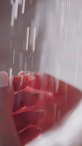 woman hands in water splashes in shower cabin closeup. lady catches clear liquid drops by palms enjoying bathing at home. spa procedure relax