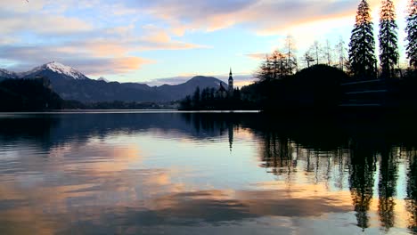 A-small-church-on-a-distant-island-at-dawn-at-Lake-Bled-Slovenia