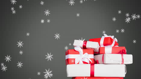 animación digital de copos de nieve cayendo sobre regalos de navidad contra un fondo gris