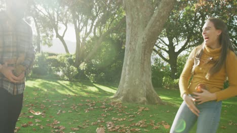 video de una feliz pareja caucásica vestida cálidamente en el jardín