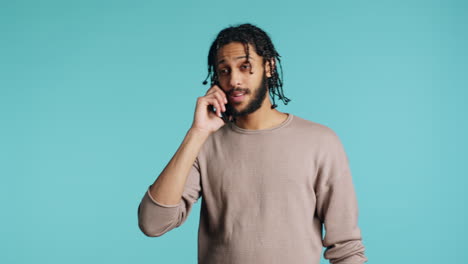 hombre discutiendo con su mejor amigo por teléfono usando un teléfono inteligente, estudio