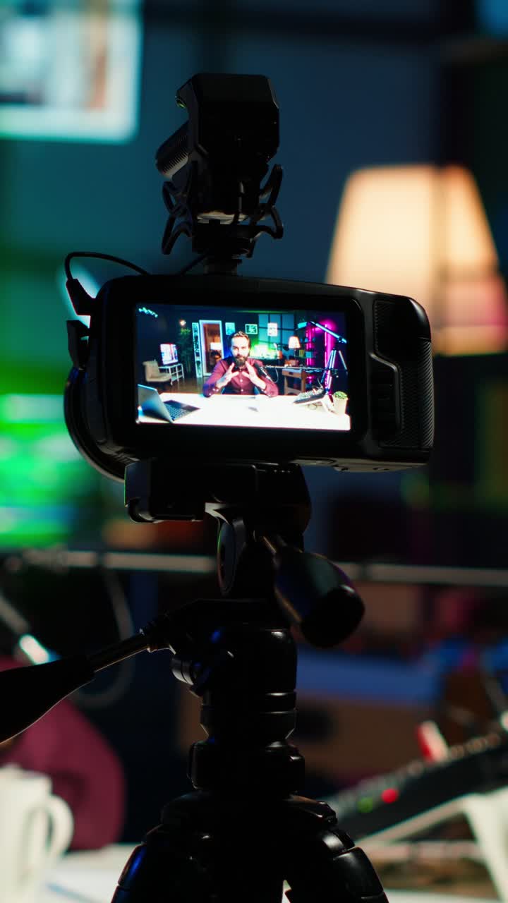 Video verticale. Focus su una fotocamera professionale utilizzata da un uomo che presenta un programma online