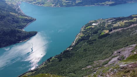 Fantastic-view-from-mount-Hoven-Loen-Nordfjord---Looking-at-Loen-Skylift-mast-on-mountain-top-before-panning-left-and-down-to-reveal-Nordfjord-and-steep-mountainside---Aerial-Norway