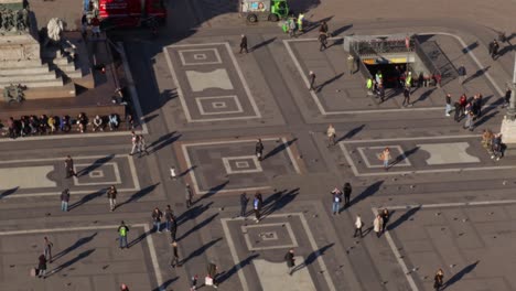 slow pan of duomo piazza with people walking and hangin out on the piazza seen from the top of the duomo cathedral