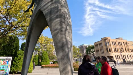 dos personas hablando cerca de una escultura al aire libre abstracta