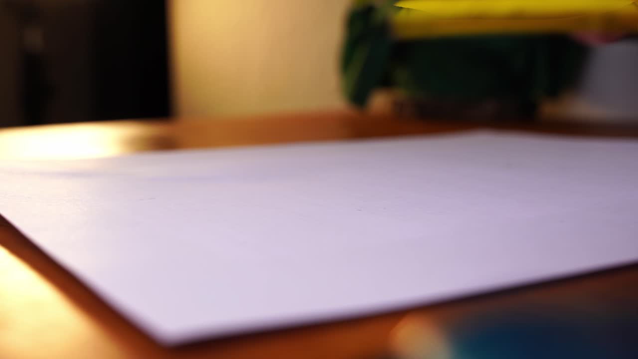 se pone un pequeño lápiz de color amarillo sobre un papel blanco y se vuelve a quitar