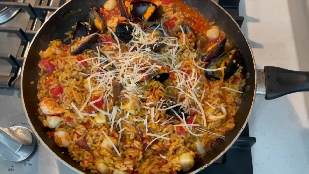 paella. mano agregando queso rallado