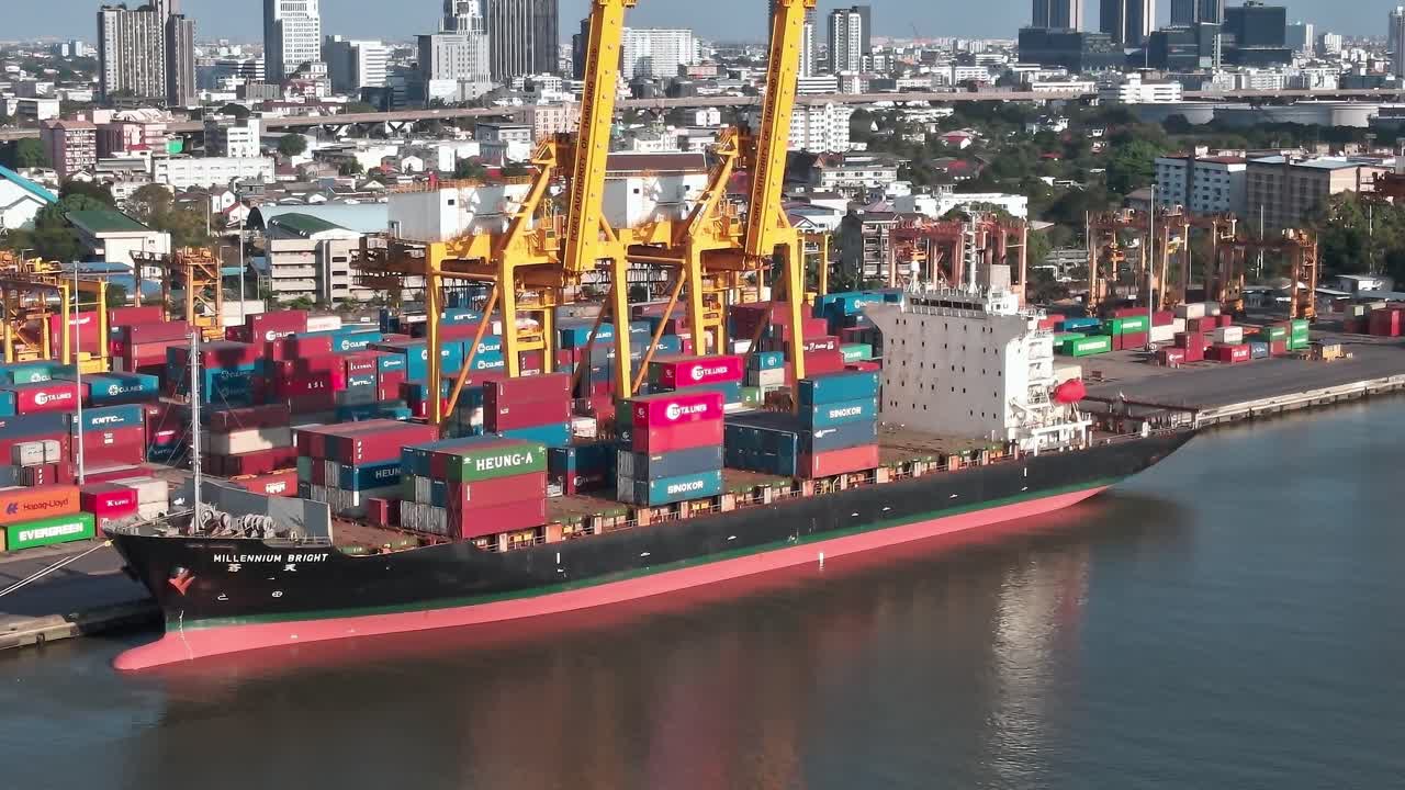 View of cargo ship and containers in Bangkok port near city skyline