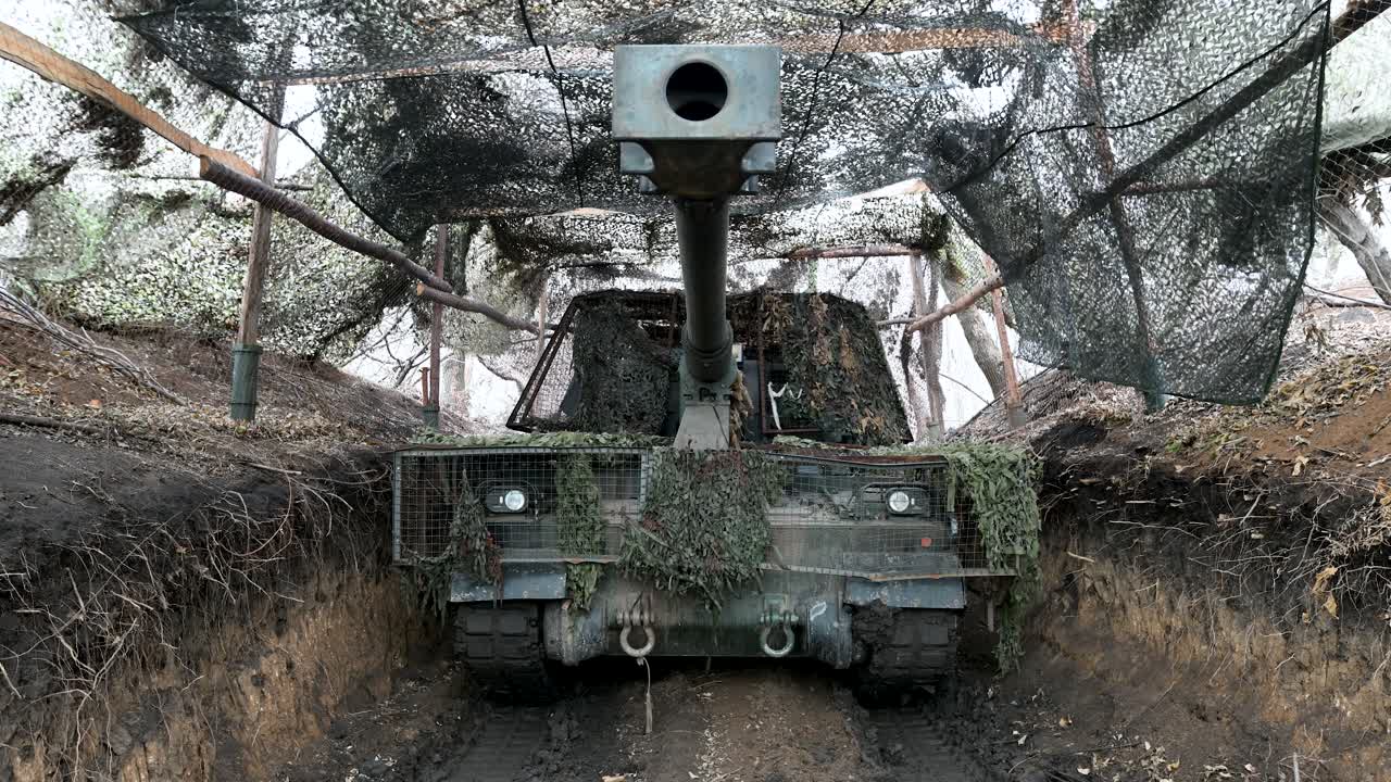 A Ukrainian PzH 2000 howitzer sits in a camouflaged firing position. This view shows a key player in the long-range artillery duels that define much of the war in Ukraine