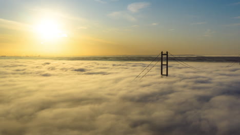 Luftaufnahme-Der-Humber-Brücke,-Während-Die-Sonne-Aufgeht-Und-Tiefe-Wolken-Und-Nebel-Sehr-Schnell-Vorbeiziehen